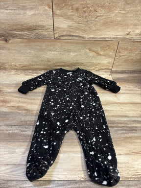 Front view of Nike black blanket sleeper in size 6m showcasing white splatter pattern, front zipper, and covered feet on wood floor