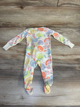 Colorful fruit print baby footed sleeper laid flat on wood floor
