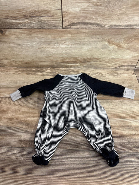 Flat lay of Gerber preemie striped footed sleeper with black raglan sleeves and gray cuffs on wood floor