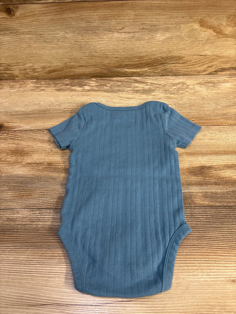 Flat-lay of Cloud Island ribbed short-sleeve baby bodysuit (12 months) showcasing vertical ribbing on wood background