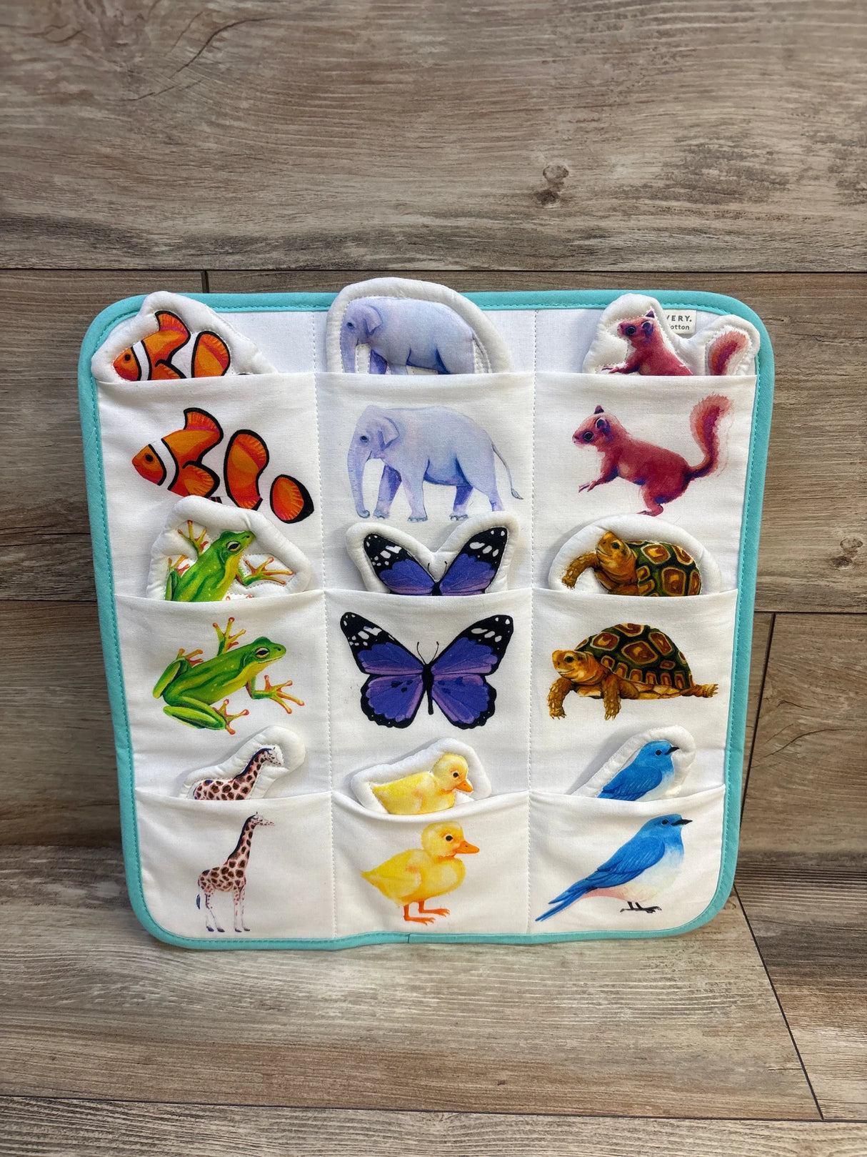 Colorful animal-themed baby quiet book with pockets featuring fish, elephant, butterfly, frog, turtle, giraffe, duck, and bird.