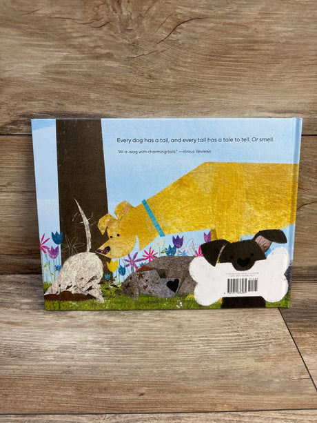 Back cover of Love Tails hardcover book with illustrated dogs and headline ‘Every dog has a tail’ on wooden floor