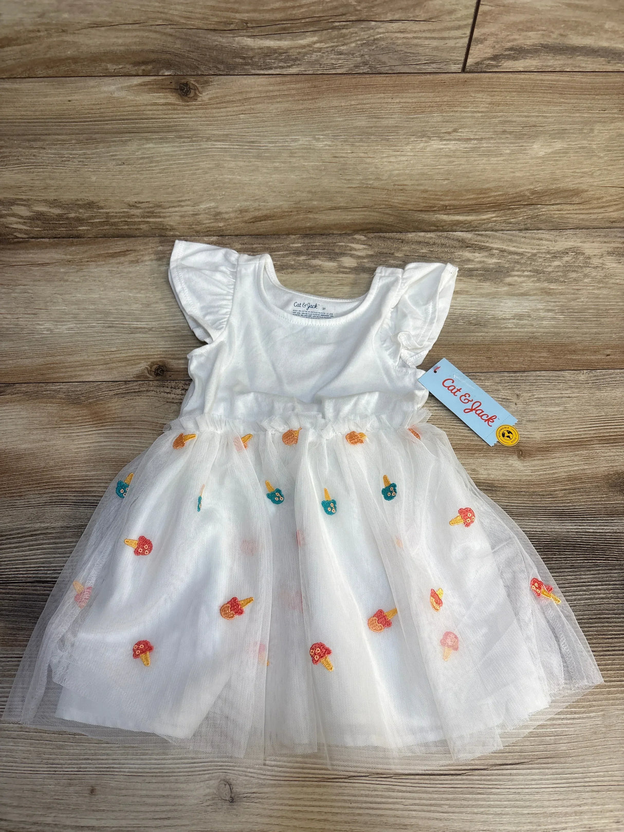 White toddler dress with ruffled sleeves and colorful mushroom embroidery on tulle skirt