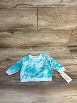 Blue tie-dye baby long sleeve shirt with tag, displayed on wooden floor