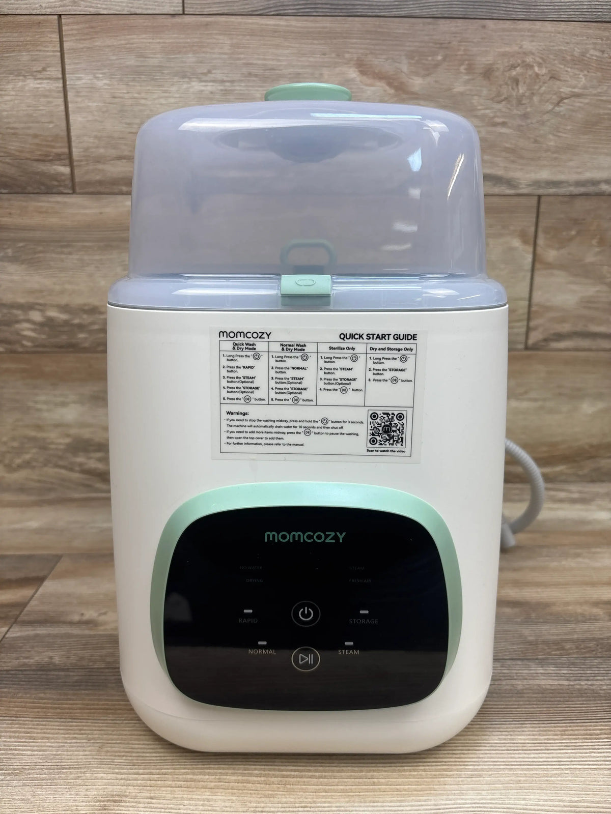 Front view of Momcozy KleanPal Pro baby bottle washer, sterilizer and dryer with translucent lid and control panel