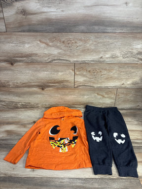 Orange pumpkin hoodie and black jack-o'-lantern pants for kids, Halloween outfit set on wood floor