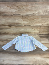 Back view of toddler blue plaid Tommy Hilfiger long-sleeve button-up shirt laid flat on wood plank background