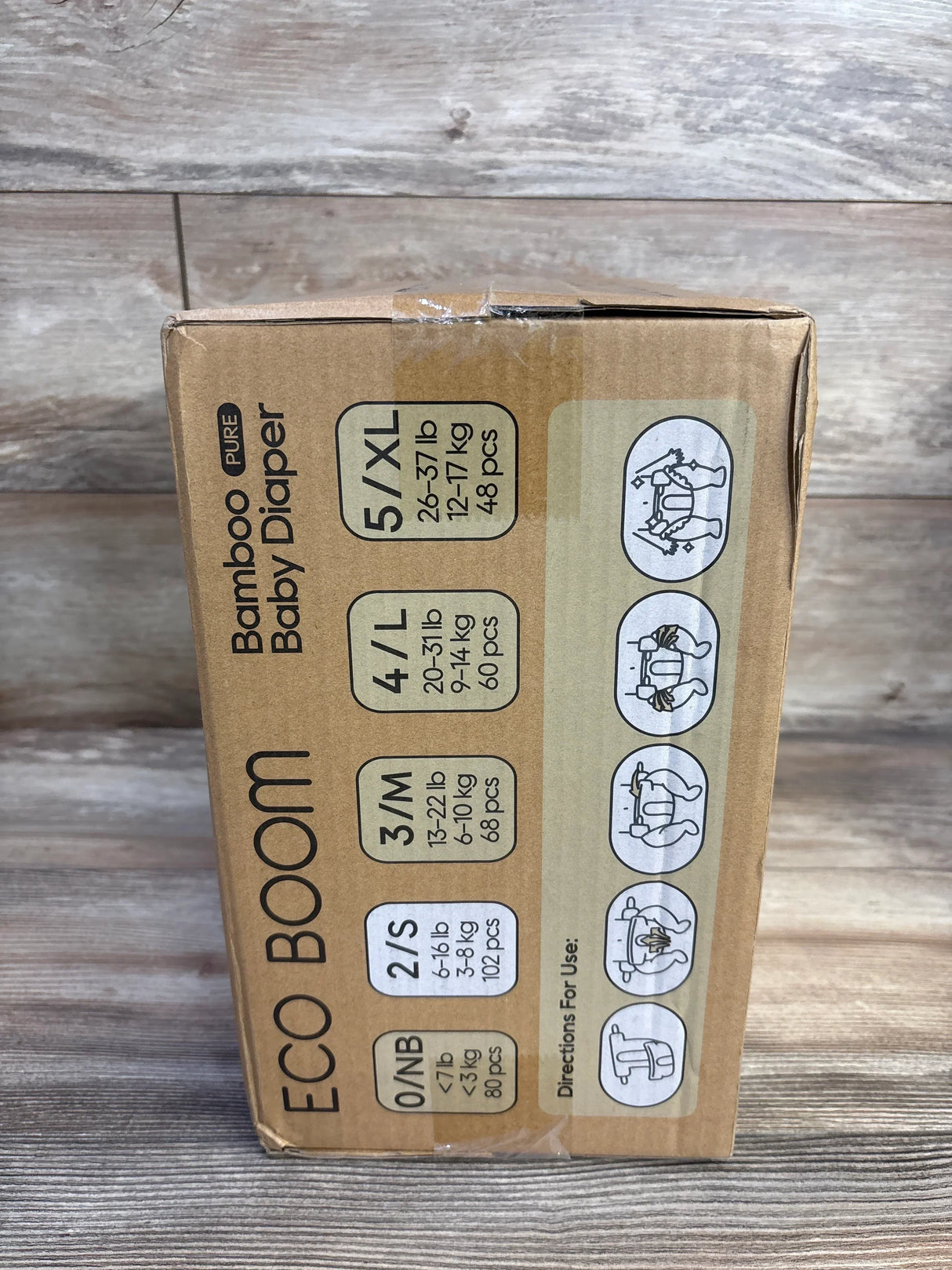 Angled view of Eco Boom bamboo diaper box showcasing 2/S size label 6–16 lb 102 pcs and usage icons on wood background
