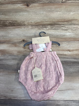 Front view of pink embroidered bubble romper and matching headband on hanger, showing floral embroidery and size 3-6M tag, wood background