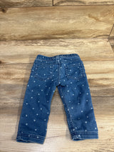 Back view of blue Cat & Jack jeggings with elastic waistband, back patch pockets, and white heart print on wood background