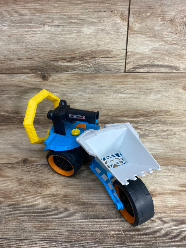 Matchbox blue and white toy construction loader with yellow handle on wood floor