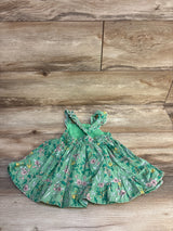 Flat lay of Cat and Jack green floral tank dress, size 18 months, showing ruffled hem, smocked waist, and crisscross straps on light wood background