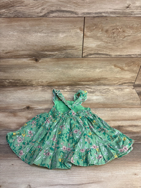 Flat lay of Cat and Jack green floral tank dress, size 18 months, showing ruffled hem, smocked waist, and crisscross straps on light wood background