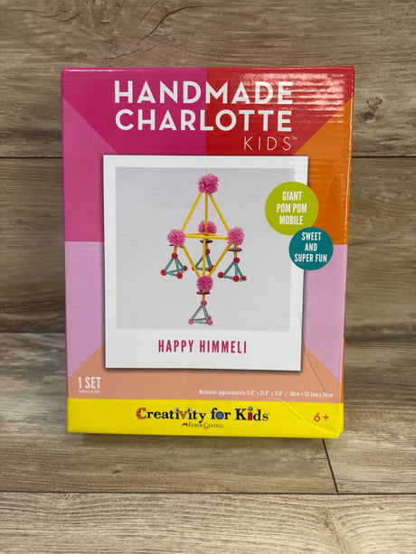 Front view of Handmade Charlotte Kids Happy Himmeli craft kit packaging showcasing a giant pom pom mobile