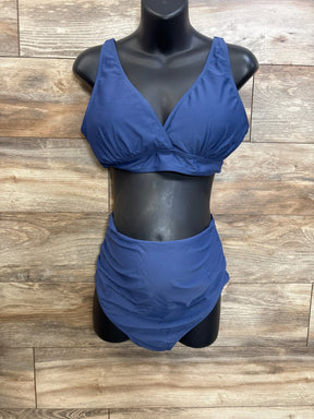 Front view of navy maternity swimsuit two-piece, V-neck top and ruched high-waist bottoms on mannequin, wood background
