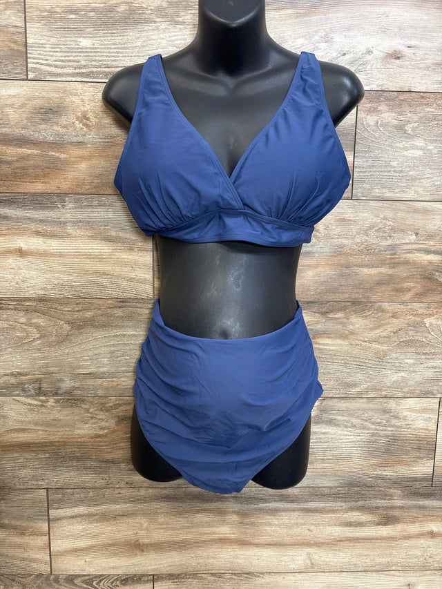 Front view of navy maternity swimsuit two-piece, V-neck top and ruched high-waist bottoms on mannequin, wood background