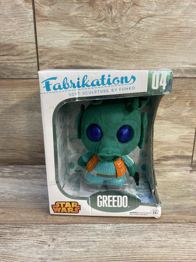 Front view of Funko Fabrikations Greedo plush in box with large purple eyes and orange straps on wood background