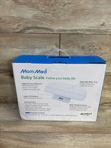 Front view of MomMed Baby Scale box showing scale image and headline Baby Scale Follow your baby life on wooden floor