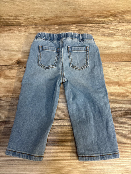 Light blue toddler jeans with elastic waist, laid flat on wood floor for kids clothing resale