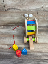 Wooden colorful pull-along snail toy with a red string and three shape blocks on wood floor
