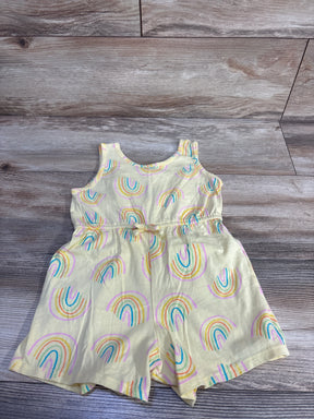 Front flat-lay of yellow Old Navy sleeveless shortie romper showcasing rainbow print and tied elastic waist on wood background