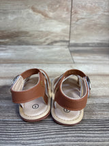 Rear view of Hsdsbebe brown soft-sole baby sandals with Velcro ankle straps and cushioned fabric insoles on wood background