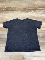 Back view of The Rolling Stones black shirt, size 18 months, showing short sleeves and a plain back on a wood surface