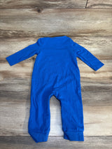 Blue baby onesie with long sleeves and legs, laid flat on wood floor
