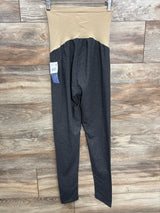 Maternity leggings with beige high waistband and dark gray legs hanging on wooden floor