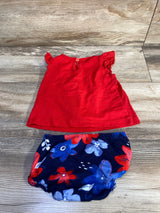 Flat lay of Carter's two-piece red eyelet top and navy floral bloomers with ruffled sleeves and elastic waist on wood floor