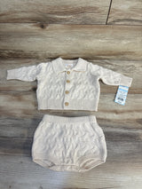 Cream cable knit baby cardigan and bloomers set, 0-3M, with wooden buttons on wood floor