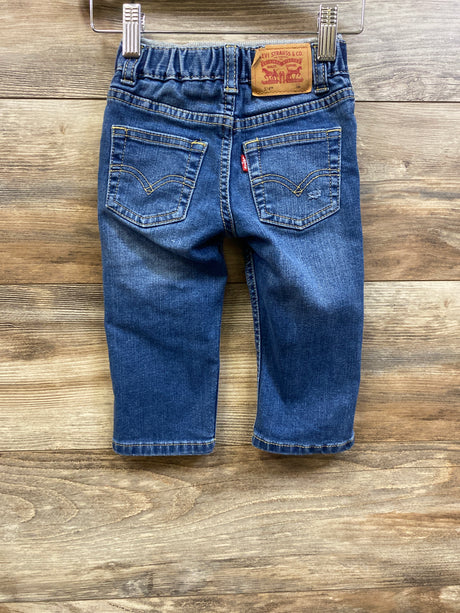 Back view of Levi’s 514 straight jeans in blue, showcasing back pockets and an elastic waistband on a wood floor