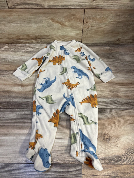 Front view of Carter’s beige blanket sleeper with dinosaur print, long sleeves, zip front and footed legs on wood
