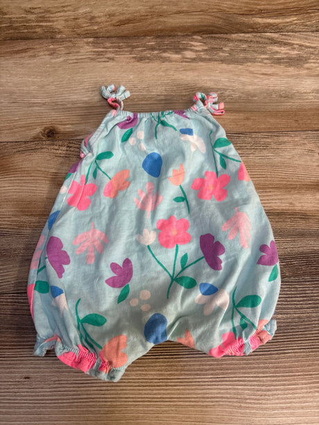 Flat lay of Carters shortie romper size 3m showcasing light blue with floral print and knotted shoulder straps on wood plank floor