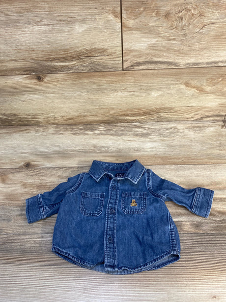 Baby denim button-up shirt with chest pockets on wood background, resale kids clothing