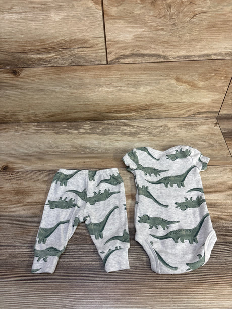 Flat lay of newborn grey dinosaur print bodysuit and matching pants, showing snap crotch and elastic waist on wood background