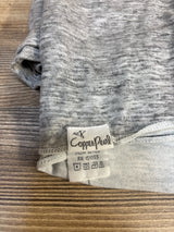 Copper Pearl gray heathered baby clothing tag on wooden surface
