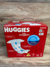 Front view of Huggies Little Snugglers size 1 box showing HUGGIES logo, 160-count and 100% blowout protection badge on wood