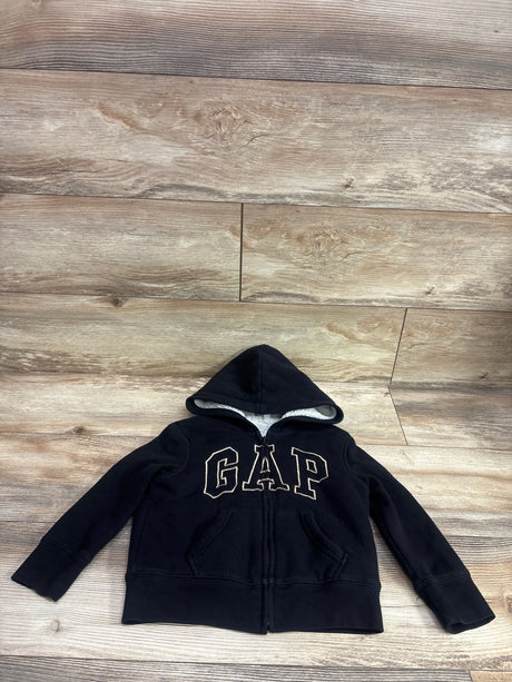 Front view of Gap Kids black logo zip hoodie, size 4-5, showcasing sherpa-lined hood on wood flooring