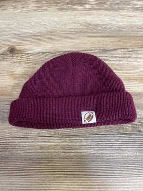 Maroon knit beanie with football patch on wooden background, kids winter hat