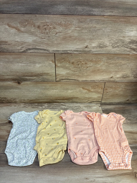 Top view of Carter’s four-piece bodysuit set in blue, yellow, pink, and peach patterns on a wood-grain background