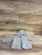 Grey Baby Gap knit hooded cardigan with bear ears and pockets on a wood background