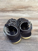 Rear view of Salt Water Sun-San sailor sandals size 7C showcasing brown braided leather straps and buckles on wood grain background