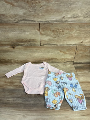 Pink Disney Princess baby onesie with blue princess print pants, kids clothing set on wood floor