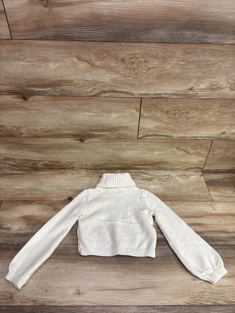 Back view of Rachel Zoe cable knit turtleneck sweater in white with ribbed collar, cuffs, and hem on a wood plank background