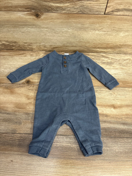 Blue long sleeve baby romper with wooden buttons on wooden background, gently used kids clothing