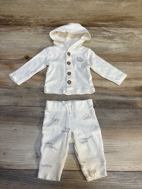 White baby outfit with hooded button-up top and animal print pants on wood background