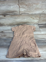 Back view of tan toddler utility romper showing short sleeves, collar, stitched waist with belt loops on wood background