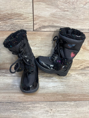 Three-quarter view of Totes Sweetheart Candy winter boots in black with faux fur trim heart patches and lace-up front