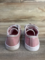 Pink glitter toddler sneakers with white soles on wood floor, rear view